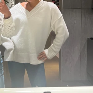 Vit stickad tröja med v-ringning - Säljer en vit stickad tröja med v-ringning och långa ärmar. Tröjan har en loose passform och ribbade detaljer vid ärmslut och nederkant. Perfekt för en avslappnad stil. 🧶