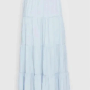 Ljusblå långkjol - Säljer en vacker ljusblå långkjol med volanger. Kjolen har en luftig och flödande design som ger en romantisk känsla. Perfekt för varma dagar och somriga kvällar. Passar utmärkt till en enkel topp eller blus.