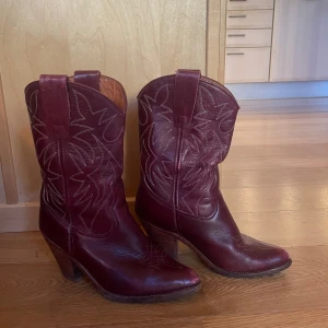 Vinröda cowboy boots - Säljer mina älskade vinröda cowboy boots då jag ska ut o resa och bygger på min resekasse. Jag har storlek 36/37 de är aningen stora på mig men skulle säga att de är perfekta för en 37/38 