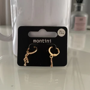 Musik Guldörhängen från Ur&penn  - Snygga guldörhängen från Montini med hängande detaljer. Perfekta för att ge en elegant touch till din outfit. De är små och diskreta men ändå stilfulla.