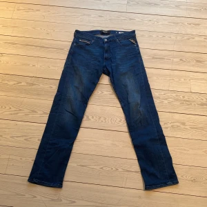 Blå jeans från Replay - Snygga blå jeans från Replay, modell Grover. De har en klassisk femficksdesign med knapp och dragkedja framtill. Perfekta för en avslappnad stil.