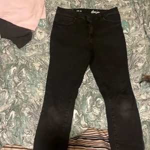 Svarta jeans från ADA - Snygga svarta jeans från ADA i storlek 40. De har en tight passform och är tillverkade i denim. Byxorna har en dragkedja och klassisk femficksdesign. Perfekta för en stilren look. Urtvättad svart färg 