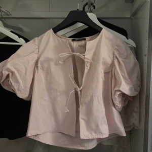 Ljusrosa blus från Gina Tricot - Säljer en söt ljusrosa blus från Gina Tricot med puffiga kortärmar och knytband framtill. Använd 2 gånger! ordinarie pris 400kr 