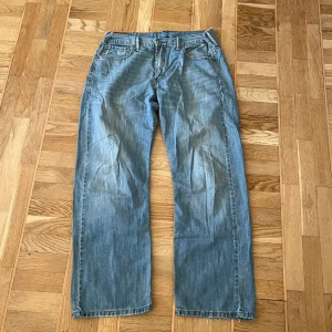 Levi's jeans i ljusblå denim - Säljer ett par klassiska Levi's 569 jeans i ljusblå denim. De har en straight passform och är tillverkade i slitstarkt jeansmaterial. Är insydda 2,5cm på vardera sida. 