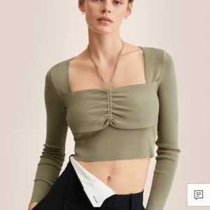 Khaki croppad topp från Mango - Säljer en snygg khaki grön croppad topp från Mango med långa ärmar och knytning framtill. Perfekt för att ge en stilren look med en twist. Toppen är i ett mjukt och bekvämt material. Inköpt för 399kr.                  Mer Info:  https://shop.mango.com/se/sv/p/dam/stickade-trojor-och-koftor/varma-trojor/troja-med-rynkdetaljer_27024018?c=37&utm_source=etiqueta&utm_medium=qr&utm_content=m&utm_campaign=mango-qr
