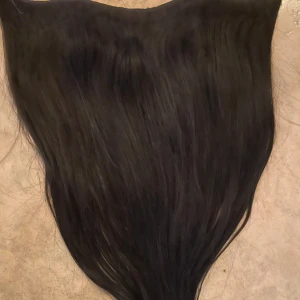 Svart löshår - Säljer ett svart löshår med slät och glansig yta. Perfekt för att ge extra längd och volym till ditt hår. Passar bra för olika frisyrer och tillfällen.