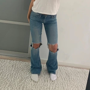 Blå bootcut jeans med slitningar - Snygga blå bootcut jeans med slitningar på knäna från crocker. Ett av mina favoritjeans, därav högt pris! 