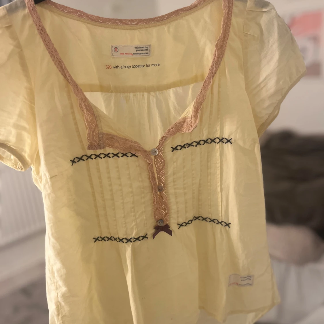 Gul blus med spetsdetaljer