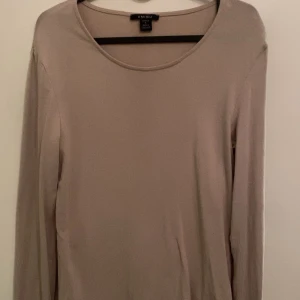Beige långärmad tröja från newyorker - Säljer en stilren beige långärmad tröja från  new yorker. Perfekt för en avslappnad look. Tröjan har en rund halsringning och är gjord i ett mjukt material.