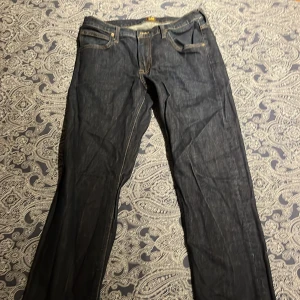 Svarta jeans från Lee - Snygga svarta jeans från Lee med klassisk femficksdesign och dragkedja. Perfekta för en stilren look. Passar bra till både vardag och mer uppklädda tillfällen. Nyskick 