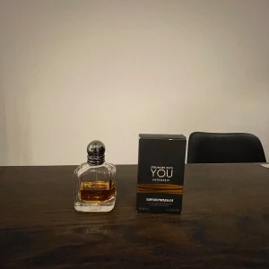 Stronger With You Intensely från Emporio Armani 23 ML KVAR - Säljer en elegant parfymflaska av Stronger With You Intensely från Emporio Armani. Flaskan har en stilren design med en mörk kork och bärnstensfärgad vätska. Perfekt för den som vill ha en intensiv och sofistikerad doft.