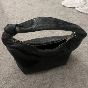 Svart handväska  - Snygg väska i svart skinn, i ett fint mönster. Jätterymlig och bra storlek! Liten innerficka inuti. Köpt på Zalando 