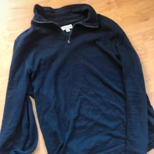 Mörkblå långärmad tröja med dragkedja - Säljer en mörkblå långärmad tröja från Lands' End. Tröjan har en praktisk dragkedja vid halsen och är perfekt för kyligare dagar. Den är stilren och enkel att matcha med olika outfits.