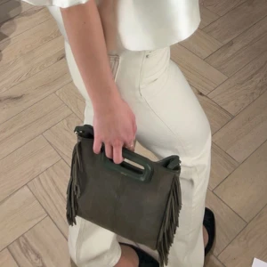 Maje väska  - Säljer min älskade älskade älskade maje väska i grönt! 💚💚Det är den stora modellen, i en mörkgrön mocka. Axelrem följer självklart med. Den är i fint skick, och passar till allt!! Skriv privat för fler bilder🥰🙏🏻 (ps. säljer även en liten maje väska i guld på mitt konto) Pris går att diskutera!