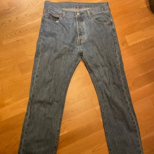 Levi's 501 jeans - Klassiska Levi's 501 jeans i blå denim med rak passform. Dessa jeans har en traditionell femficksdesign och knappgylf. Perfekta för en avslappnad stil.