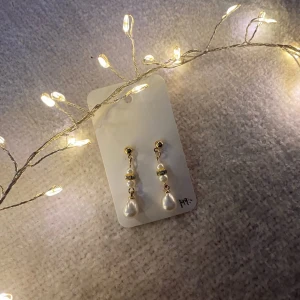Guldiga hängen med vita pärlor  - Hållbart skapade - Tillverkade i återvunnet material för att bidra till en mer hållbar framtid 