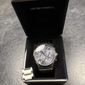 Armani klocka  - Snygg klocka från emporio Armani, köpt för ungefär två år sedan men har inte blivigt använd på ett år. Bra skick, dock har Armani märket lossnat o h ligger löst i uret, kostar runt 300kr att laga men inget jag orkat ta tag i, nypris 3700 mitt pris 1600 kan diskuteras vid snabb affär🤝men får med två extra länkar och box, den lilla boken som ör äktahets bevis samt lappen.