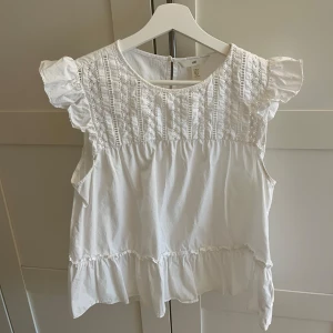 Vit blus med spetsdetaljer - Söt vit blus från H&M med spetsdetaljer. Jätte fin till sommaren💘