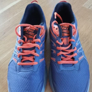 Blå och orange Asics löparskor - Säljer ett par Asics löparskor i blått med orange detaljer och snörning. Skorna har en robust sula med bra grepp, perfekt för löpning och träning. Priset är ej hugget i sten!