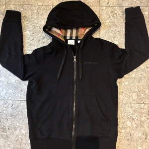 Burberry hoodie KVITTO FINNS - Säljer en svart hoodie från burberry. Den är sparsamt använd 2-3 gånger och är i perfekt skick. Tröjan är köpt i en burberry butik i England och det är samma tröja som på 3:de bilden. Kvitto finns. Xs men passar S. Vid frågor eller fler bilder, tveka inte på att skriva☺️Pris går att diskutera!