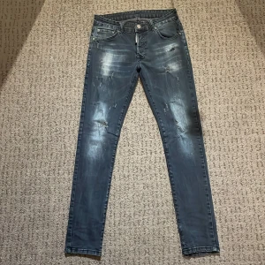 Grå jeans från Dsquared2 - Snygga grå jeans från Dsquared2 med en cool slitningseffekt. De har en klassisk femficksdesign och knappgylf. Perfekta för en trendig look. Priset går att diskuteras och byten kan vara intressanta.