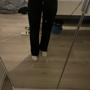 Svarta mjukisbyxor med snörning - Säljer ett par svarta mjukisbyxor med snörning i midjan. Byxorna har en avslappnad passform och är perfekta för en bekväm stil. De är tillverkade i ett mjukt material som gör dem sköna att bära.