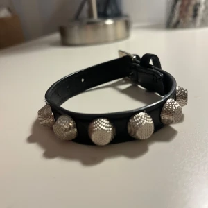 Svart armband med silvernitar - Coolt armband bälte med stora, texturerade silvernitar. Perfekt för att ge en edgy touch till din outfit. Bältet har ett klassiskt spänne i silverfärg och flera hål för justering. Balenziaga inspererat. Nypris 500🤍