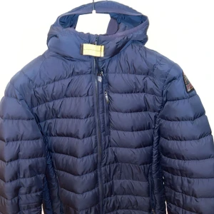 Blå dunjacka från Parajumpers - Snygg blå dunjacka från Parajumpers. Finns några skavanker men inga stora annars väldigt fin.