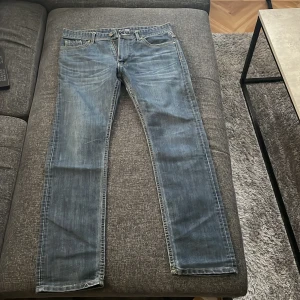 Blå jeans med tryck från Emporio Armani - Snygga blå jeans från Emporio Armani med ett tryck som jag har gjort själv. 