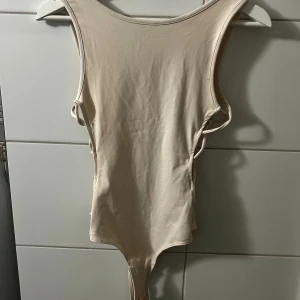 Beige body  - oanvänd beige body med snörning på sidorna från bik bok svår att få snygg på bild men otrolig snygg på, tyvärr för liten för mig