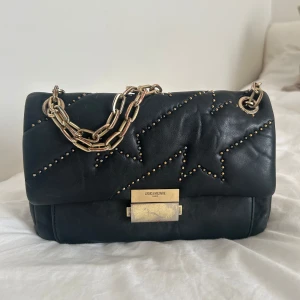 Zadig & Voltaire - Ziggy XL Bag - Black  - Black lamb skin Ziggy bag from Zadig & Voltaire featuring a quilted effect, micro stud details, a rectangular body, a foldover top with clasp closure, gold-tone hardware and a chain shoulder strap. This bag can be worn crossbody and as one shoulder. 