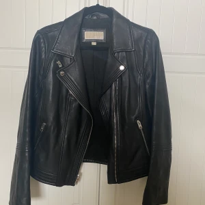 Skinnjacka - Michael kors skinnjacka med silvriga dragkedja detaljer. Använd fåtal gånger! Den är i äkta skinn/läder. Otroligt bra skick! Säljes pga att den inte används:(