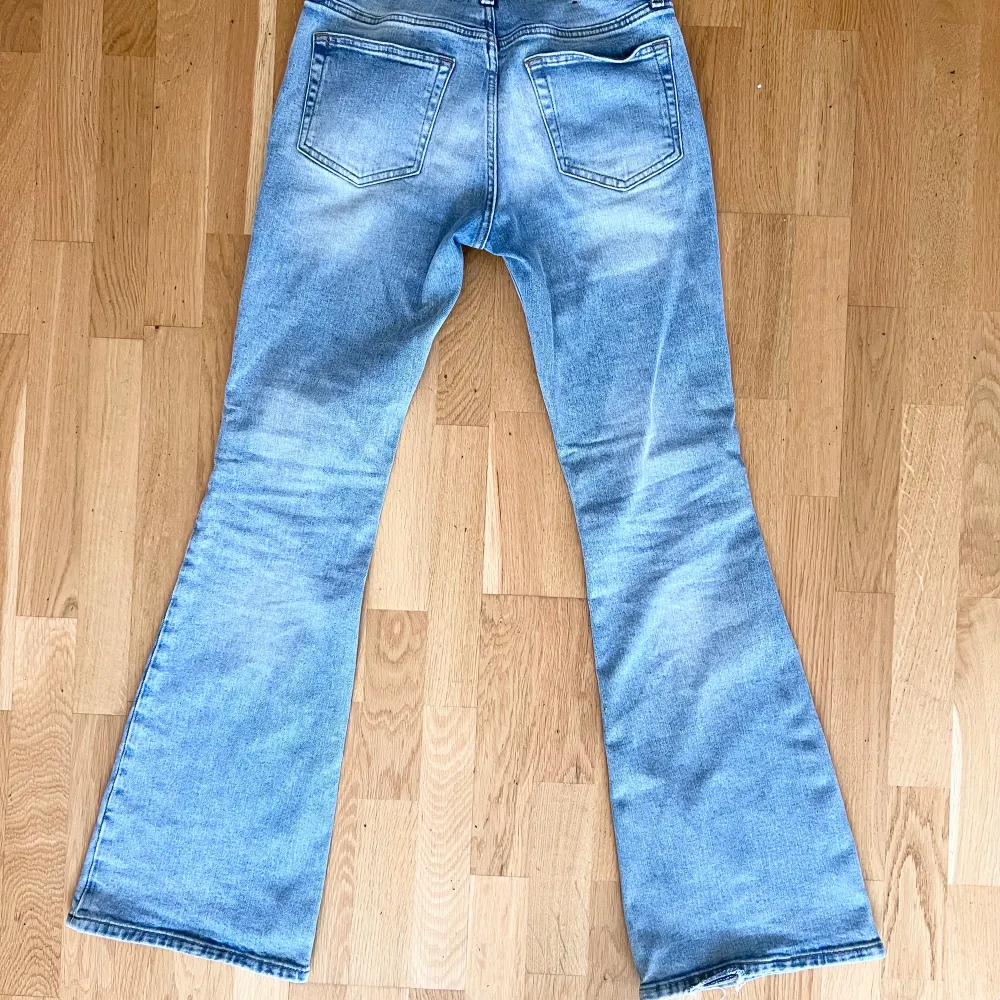 Låga ljusblå utsvängda jeans från Weekday. I modellen Flame Low Flared Jeans, i färgen Stenblå. Använda ett fåtal gånger, litet slitage på baksidan av kanten på ena byxbenet . Jeans & Byxor.