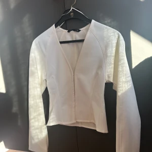 Vit figursydd jacka/topp (Zara)  - Vit figursydd topp/jacka från Zara. Oanvänd med prislapp kvar, storlek XS.