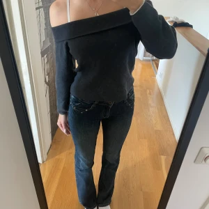 Mörkgrå offshoulder tröja - Säljer en snygg mörkgrå offshoulder tröja som är perfekt för både vardag och fest. Tröjan har en tight passform, vilket gör den både stilren och bekväm. Den är i bra skick och passar perfekt till ett par jeans för en avslappnad look.