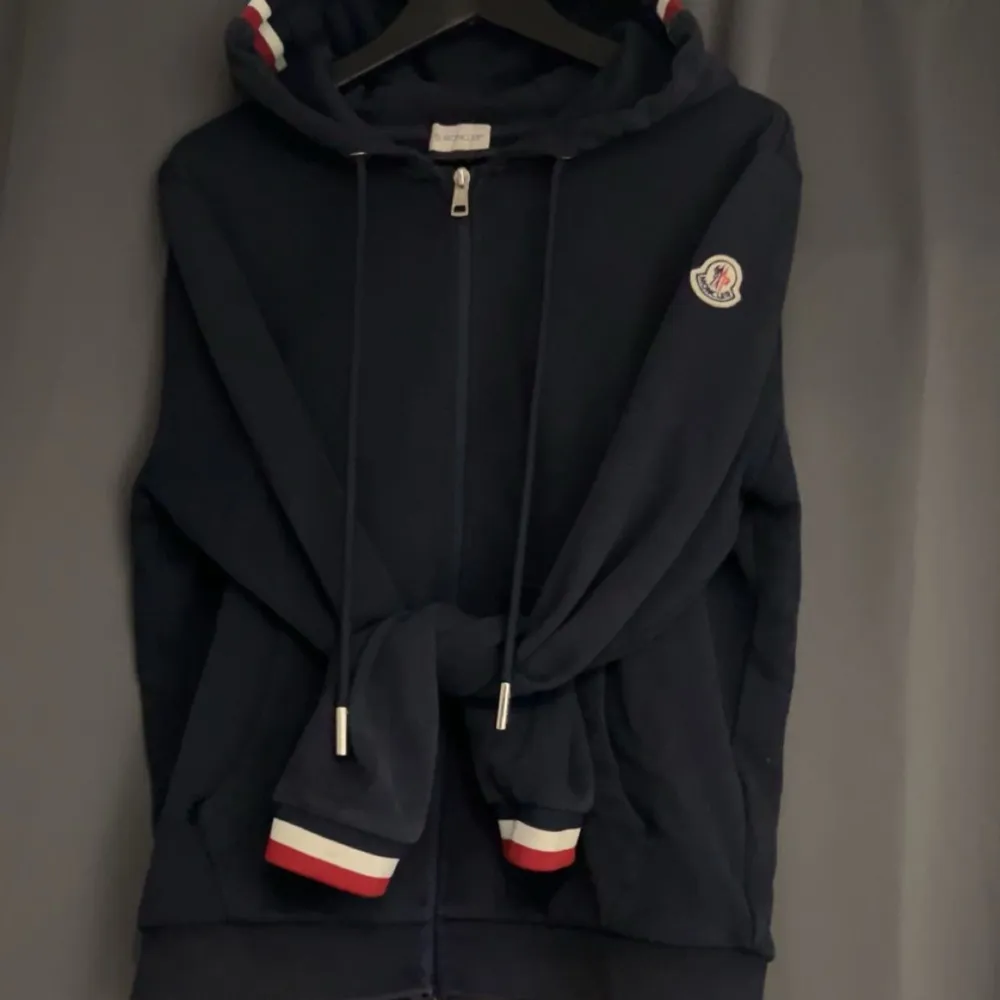 Säljer en snygg mörkblå hoodie från Moncler. Bra skick köpte den för ungefär 1 år sen av en kille här på plick. Har tagit hand om den. Den har ett litet hål på magfickan som inte syns om man t.ex har en svart t-shirt under tröjan. Inget kvitto finns.  . Hoodies.