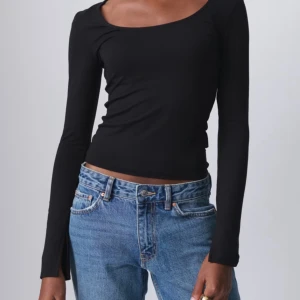 Soft touch topp från Gina tricot storlek Xs - Snygg svart långärmad topp från Gina Tricot i ett mjukt och stretchigt material. Perfekt för både vardag och fest. Den har en rundad halsringning och en liten slits vid ärmsluten för en extra detalj. Tröjan är i jättebra skick!