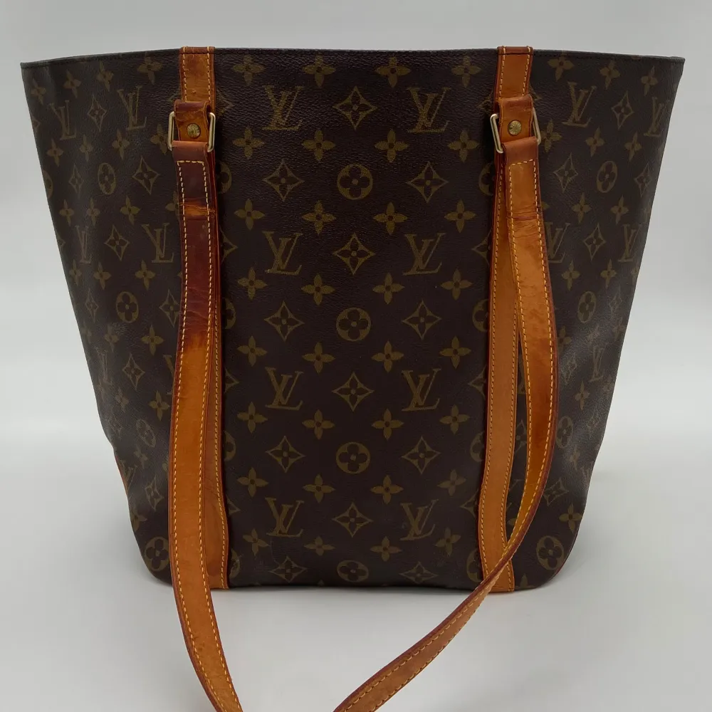 Louis Vuitton Monogram Sac Shopping Bag  Skick: C, väldigt fint vintage skick, bristningar i lädret på bandet syns ej lika mycket när väskan bärs. Se alltid bilder för egen uppfattning.  Serienummer: MB0030  Sku: V001  Mått: B25-50cm x H33cm x D14cm . Väskor.