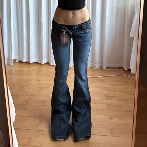 Lågmidjade bootcut jeans - Världens finaste vintage jeans från 00-tal märket Frankie B.😍tyvärr försmå! Lappen är kvar och nypris är $196, enda defekt e knappen på bild 4💓midja 38 innerben 91 grenhöjd 16, jae 165 