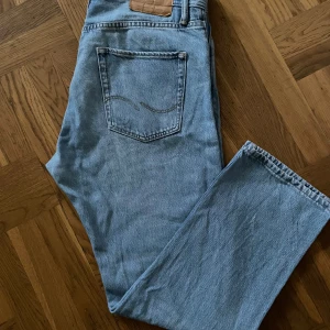Ljusblå jeans från Jack & Jones - Säljer ett par ljusblå jeans från Jack & Jones i loose fit. Perfekta för en avslappnad stil med klassisk femficksdesign. De är i bra skick och passar perfekt för vardagsbruk. Sköna och stilrena, ett måste i garderoben!