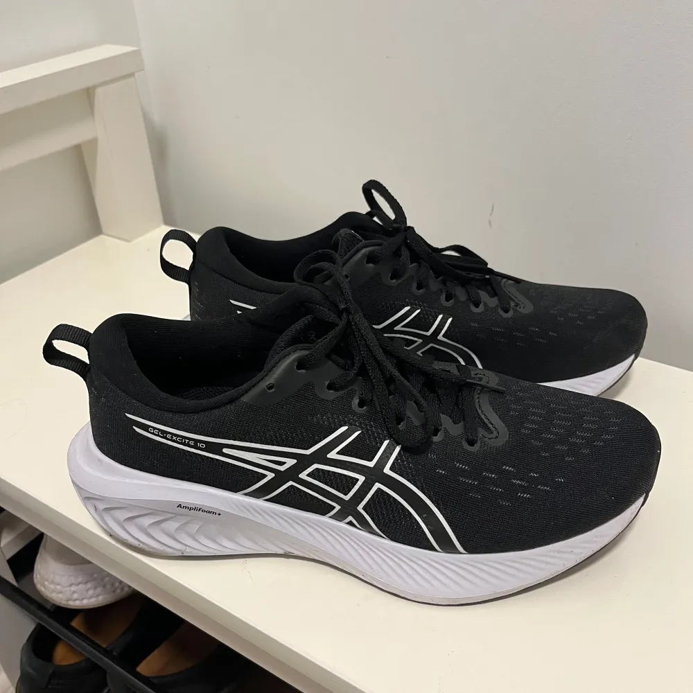 Säljer ett par svarta Asics löparskor i nyskick. De har en snygg vit sula och klassisk Asics-logga i vitt på sidan. Perfekta för träning och löpning med bra dämpning och komfort. Skorna har snörning för en säker passform. Ordinarie pris 999kr.. Skor.