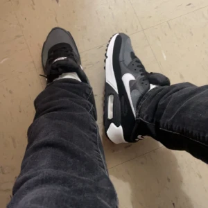 Nike Air Max i svart och grå - Säljer ett par snygga Nike Air Max i svart och grått. De har en klassisk design med vit sula och svart snörning. Perfekta för både vardag och träning. Skorna är i nyskick och redo för nya äventyr!