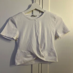 Vit T-shirt - Jättegullig vit t-shirt som har en knytning där fram, den är också i jättefint skick pågrund av dålig användning!