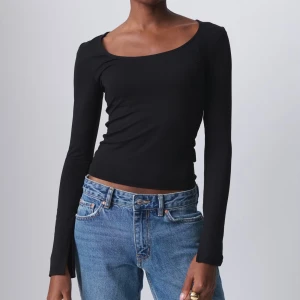 Svart långärmad topp från gina - Snygg svart långärmad topp i tight passform från gina tricot, säljs då den aldrig kommer till användning. Perfekt nu till hösten!!