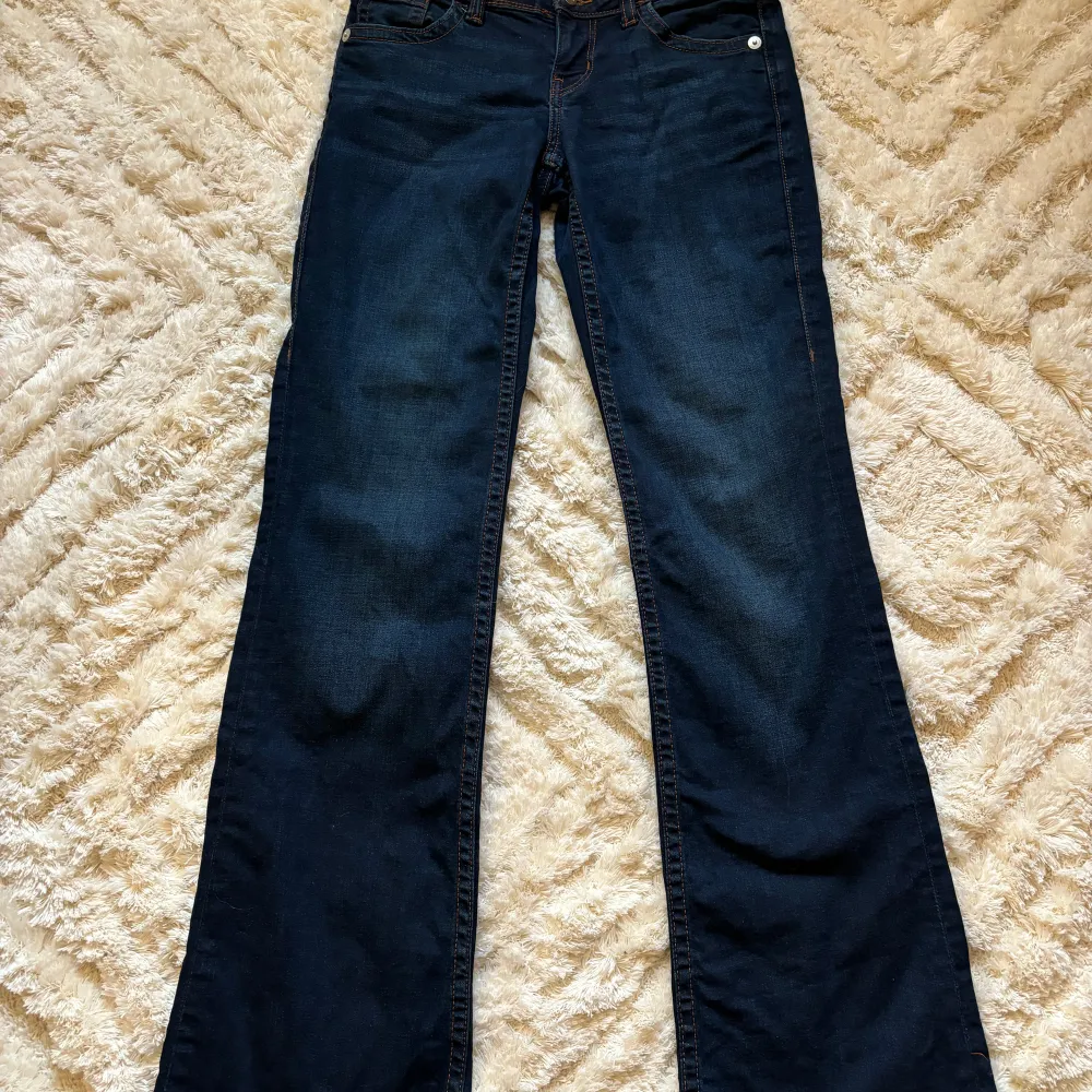 Mörkblå lågmidjade jeans med snygga detaljer på bakfickorna.  Storlek 34 från HM Mycket bra skick!  170kr ex frakt! Pris kan diskuteras! 💜. Jeans & Byxor.