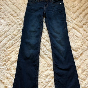 Lågmidjade mörkblå jeans - Mörkblå lågmidjade jeans med snygga detaljer på bakfickorna.  Storlek 34 från HM Mycket bra skick!  170kr ex frakt! Pris kan diskuteras! 💜