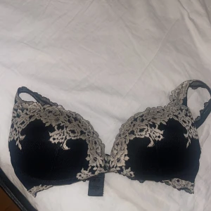 Svart bh med spetsdetaljer - Elegant svart bh med vackra spetsdetaljer i beige. Perfekt för att känna sig extra fin under kläderna. Den har justerbara axelband för bästa passform.