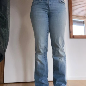Ljusblå lågmidjade jeans  - Snygga ljusblå jeans med låg midja och klassisk femficksdesign. De har en rak passform och sitter bekväm mot kroppen. Jeansen har en knapp och dragkedja framtill. De har ett litet ”slit-hål” under höger knä. Jag har klippt bort lappen och vet inte vilket märke. Storleken funkar för 36 och 38 beroende på hur man vill att de ska sitta (jag är närmre 38) 