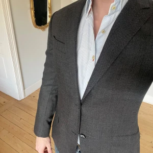 Grå kavaj från Oscar Jacobson - Otroligt vacker grå kavaj från Oscar Jacobson med riktigt häftigt tyg. Vissa knappar är skadade, annars i riktigt fint skick. Storlek 48. 