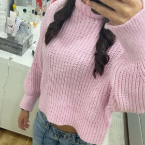 Rosa stickad polotröja - Säljer en mysig rosa stickad polotröja med ribbade detaljer. Tröjan har långa ärmar och en bekväm passform, perfekt för kyligare dagar. Passar bra till jeans eller kjol för en avslappnad look.